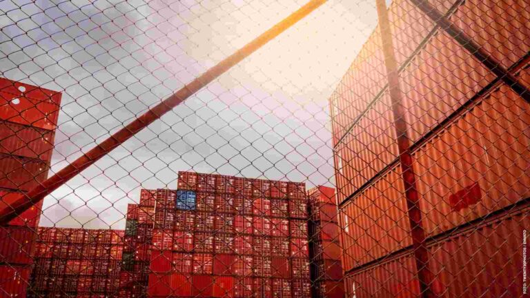 View from fence of red container stacked. Container logistics. C