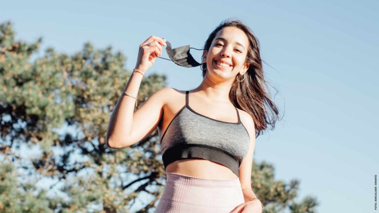 Young woman on sport clothes putting off face mask after being l