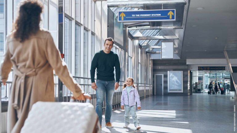 Happy father with little girl meeting wife at the airport termin