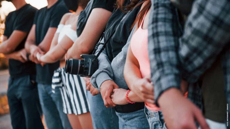 Photographer with camera. Group of protesting young people that standing together. Activist for human rights or against government