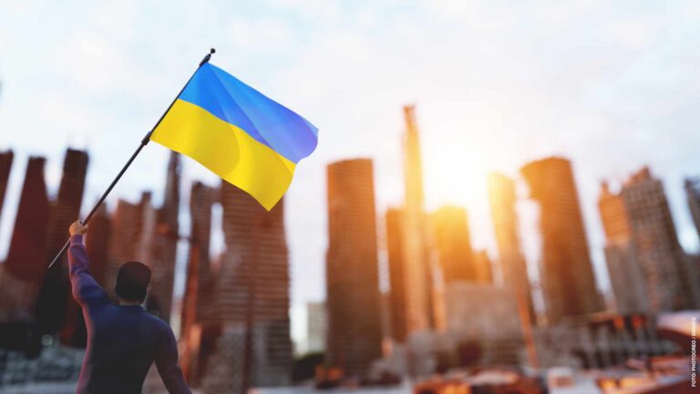 Man with Ukraine flag on city ruin. Ukrainian victory