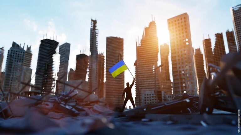 Man with Ukraine flag on city ruin. Ukrainian victory