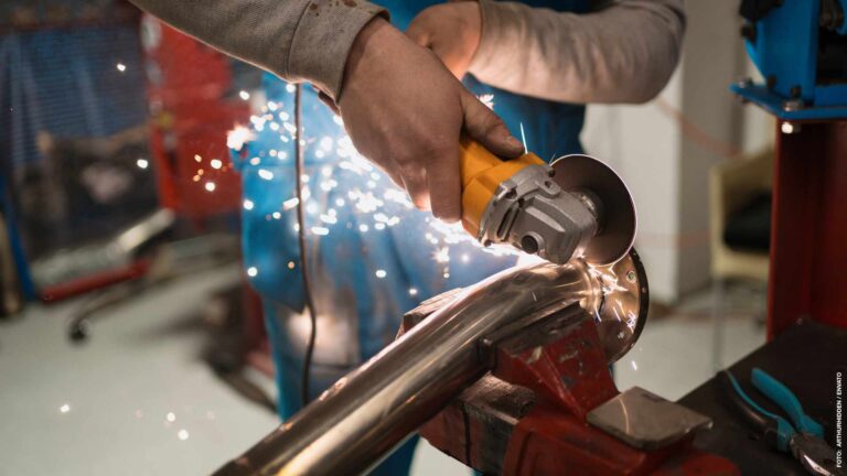 Worker working with a circular grinder on a metal with sparks
