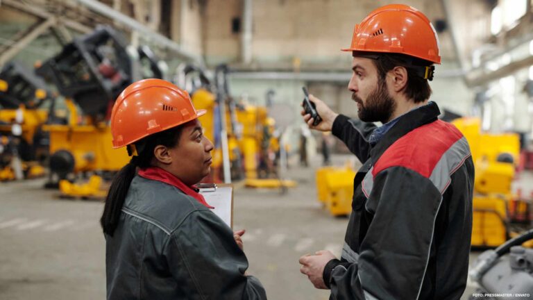 Two young confident engineers in workwear having discussion