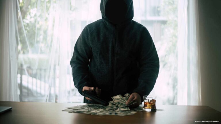 Hooded criminal gun shooting with dollar