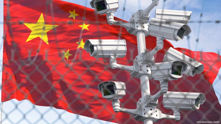 Flag of China behind barbed wire fence and cctv cameras. Concept
