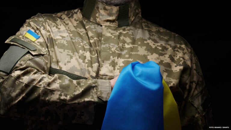 Ukrainian soldier holds a flag of the independent state of Ukrai