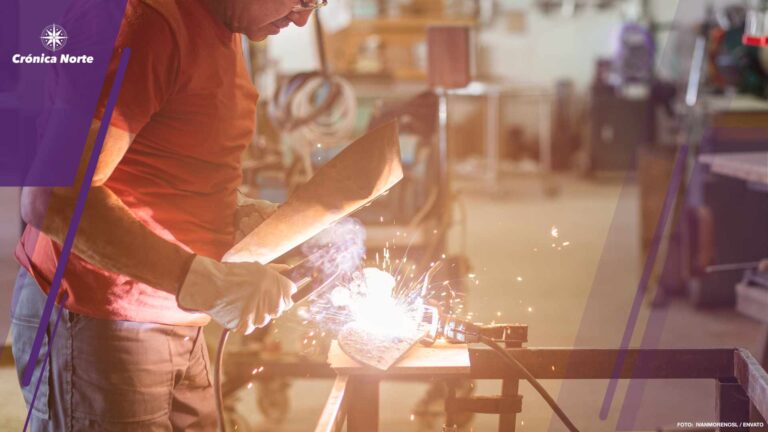 Person in red T-shir welding with a shield