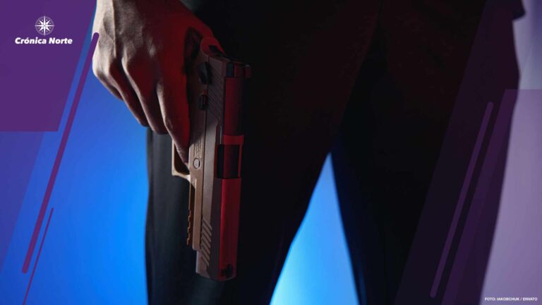 Person holding pistol near his legs indoors