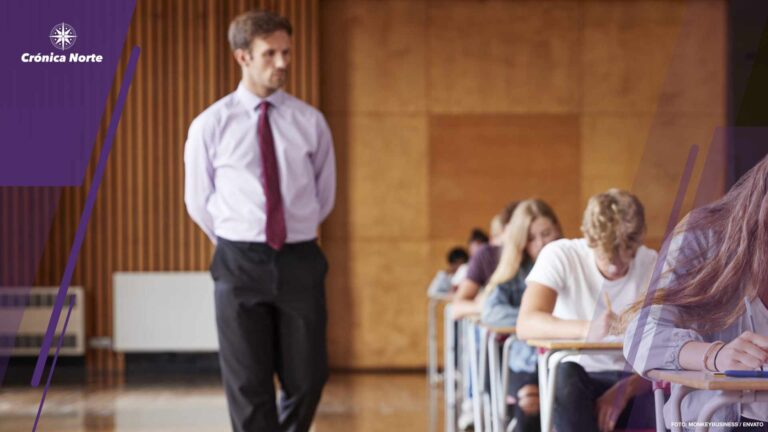 Teenage Students Sitting Examination With Teacher Invigilating
