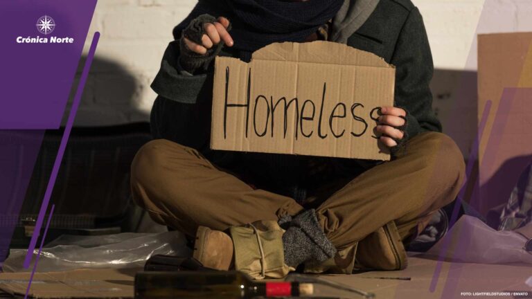 cropped view of homeless man holding piece of cardboard with"hom