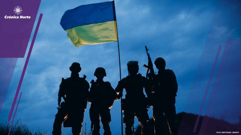 Four armed Ukrainian soldiers with a national flag in the evening