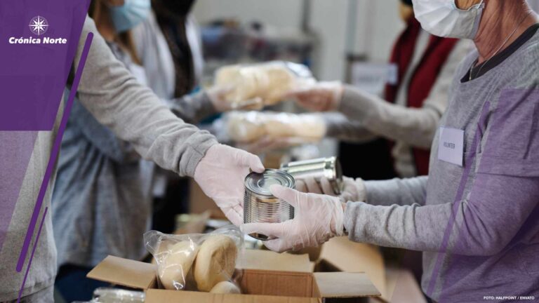 Group of volunteers in community donation center, food bank and coronavirus concept.
