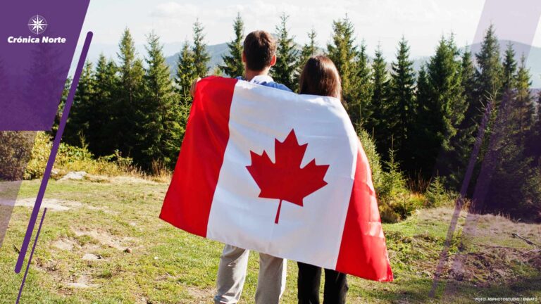 Happy Canada Day. Couple with large Canadian flag celebration in