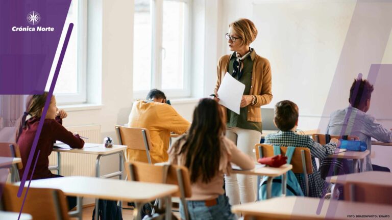 Mature teacher holding a class to group of school kids at primary school.