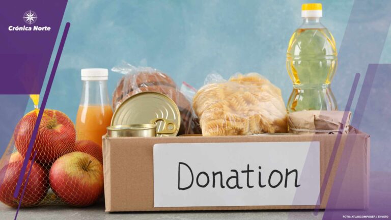 Donation box with different food on gray table. Volunteering