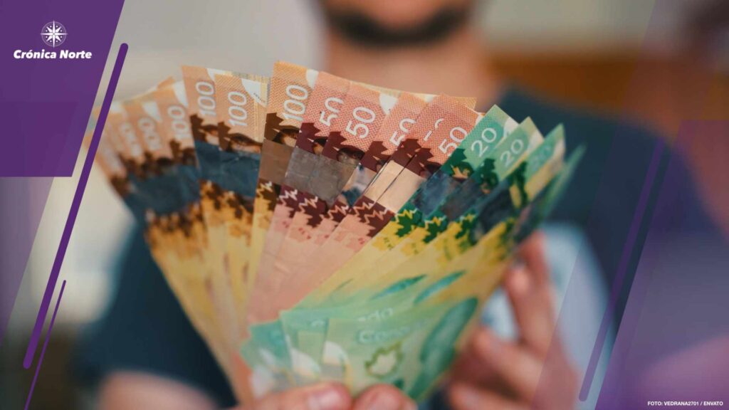 Midsection of man holding banknotes of Canadian dollars