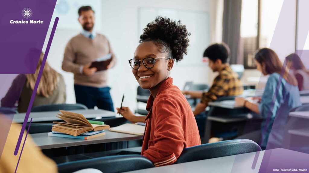 Happy black university student attending a lecture in the classroom and looking at camera.