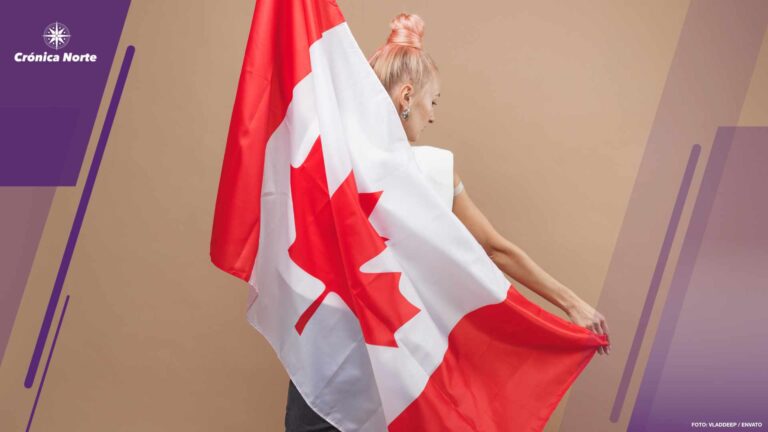 Beautiful blonde woman standing with Canadian flag