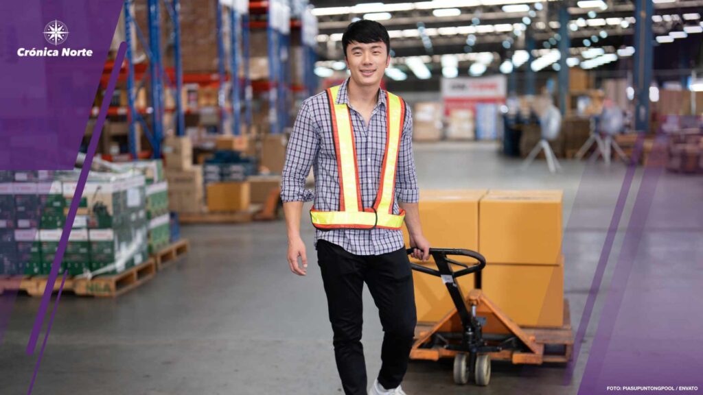 Warehouse worker pulling manual hand pallet lift