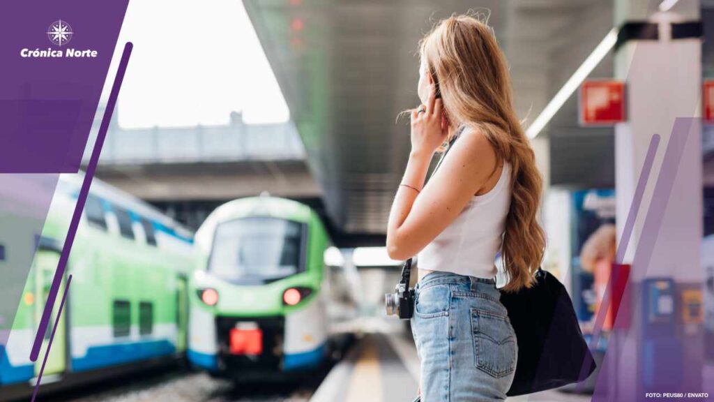 Young caucasian woman waiting train at railway platform for arri